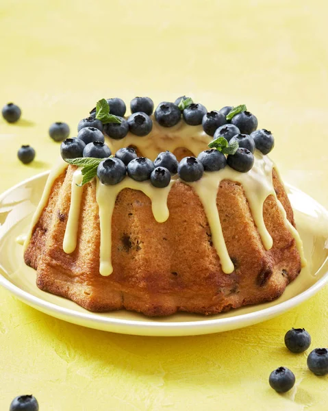 Blaubeerkuchen mit Sahnehäubchen auf gelbem Hintergrund — Stockfoto