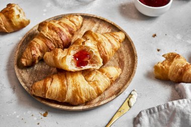 Kahvaltıda tereyağlı ve çilekli taze kruvasan..