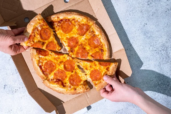 La gente toma las manos rodajas de pizza de pepperoni. — Foto de Stock