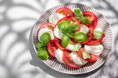 Mozzarella soslu salata caprese, dilimlenmiş domates, baharat ve taze fesleğen. Ev yapımı yemek..