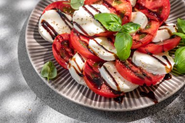 Mozzarella soslu salata caprese, dilimlenmiş domates, baharat ve taze fesleğen. Ev yapımı yemek..