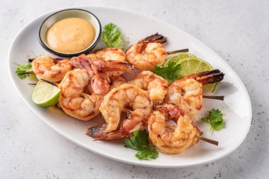 Izgara karides. Karides şiş, limon ve taze otlar.