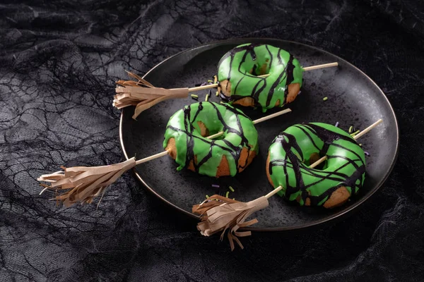 Halloween-Donut mit grüner Glasur und Hexenbesen. Süßes oder Saures. — Stockfoto