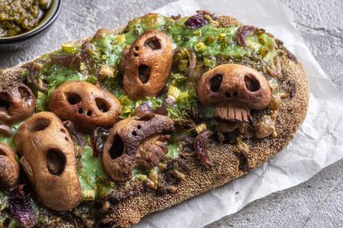 Kafatası şekilli mantarlı Cadılar Bayramı ürkütücü pizza ekmeği..