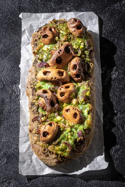 Pão de pizza assustador de Halloween com cogumelo em forma de crânio. — Fotografia de Stock