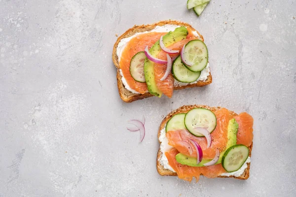 Krem peynirli çavdar ekmekli sağlıklı tost, somon, salatalık ve kırmızı soğan.