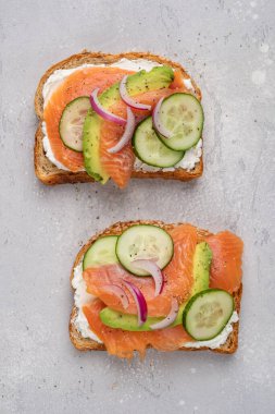 Krem peynirli çavdar ekmekli sağlıklı tost, somon, salatalık ve kırmızı soğan.