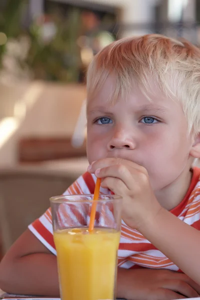 Little boy with a orange juice — Stock Photo, Image