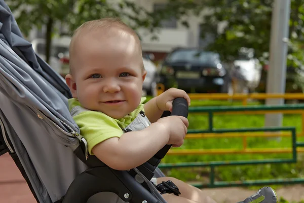 Förtjusande baby boy i en stoller — Stockfoto