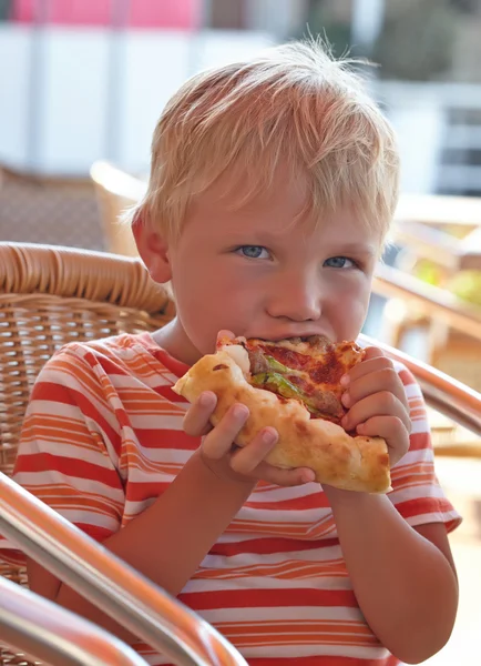 Kleine jongen een pizza eten — Stockfoto