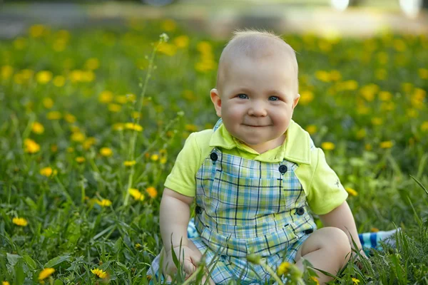 Yeşil çimenlerin üzerinde oturan erkek bebek — Stok fotoğraf