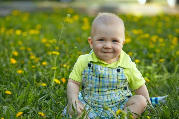 Menino sentado na grama verde — Fotografia de Stock