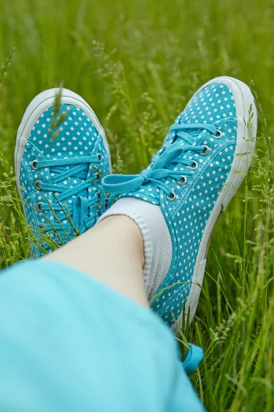 Πόδια σε πάνινα παπούτσια για την πράσινη χλόη — Φωτογραφία Αρχείου