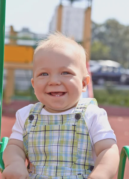Adorable niño divirtiéndose en un columpio al aire libre — Foto de Stock