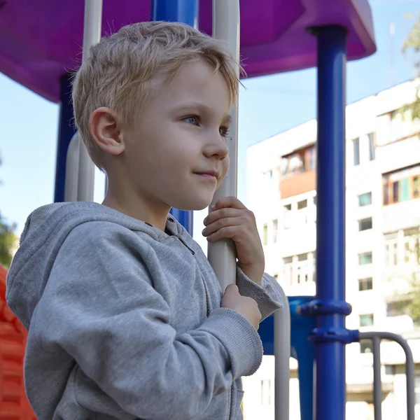 Niño jugando en un patio de recreo — Foto de Stock