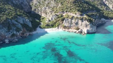 Turkuaz deniz suyu ve taş iskeleli güzel bir sahil manzarası. İtalya 'daki Sardunya adaları, insansız hava aracı atışı. Yaz deniz manzarası
