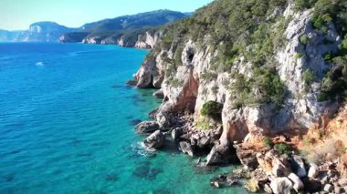 Turkuaz deniz suyu ve taş iskeleli güzel bir sahil manzarası. İtalya 'daki Sardunya adaları, insansız hava aracı atışı. Yaz deniz manzarası