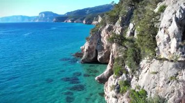 Turkuaz deniz suyu ve taş iskeleli güzel bir sahil manzarası. İtalya 'daki Sardunya adaları, insansız hava aracı atışı. Yaz deniz manzarası