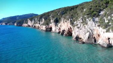 Turkuaz deniz suyu ve taş iskeleli güzel bir sahil manzarası. İtalya 'daki Sardunya adaları, insansız hava aracı atışı. Yaz deniz manzarası