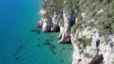 Turkuaz deniz suyu ve taş iskeleli güzel bir sahil manzarası. İtalya 'daki Sardunya adaları, insansız hava aracı atışı. Yaz deniz manzarası