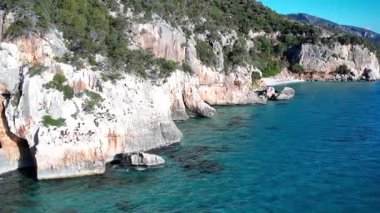 Turkuaz deniz suyu ve taş iskeleli güzel bir sahil manzarası. İtalya 'daki Sardunya adaları, insansız hava aracı atışı. Yaz deniz manzarası