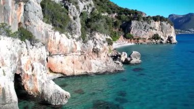 Turkuaz deniz suyu ve taş iskeleli güzel bir sahil manzarası. İtalya 'daki Sardunya adaları, insansız hava aracı atışı. Yaz deniz manzarası