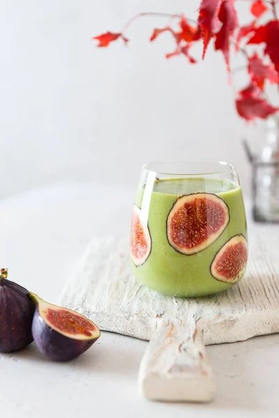 Matcha green tea breakfast superfoods smoothie with figs in a glass. Side view, copy space for text. Japanese matcha tea drink, dessert. Healthy superfoods, detox, diet