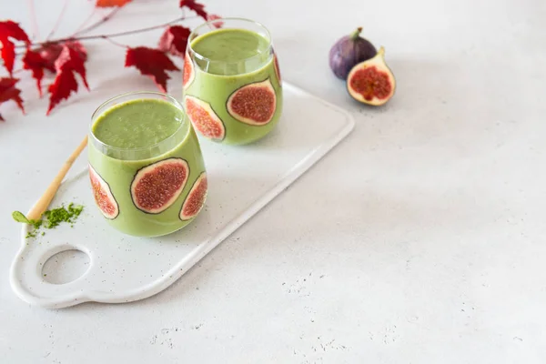 Matcha green tea breakfast superfoods smoothie with figs in a glass. Side view, copy space for text. Japanese matcha tea drink, dessert. Healthy superfoods, detox, diet
