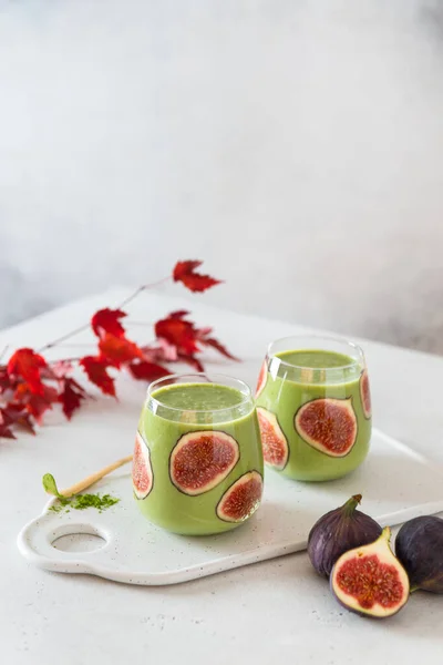 Matcha green tea breakfast superfoods smoothie with figs in glasses. Side view, copy space for text. Japanese matcha tea drink, dessert. Healthy superfoods, detox, diet