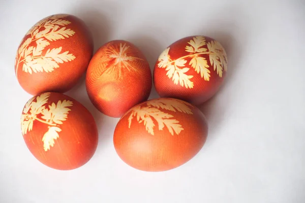 Painted Easter eggs on a white background. Floral pattern on a red eggshell. Festive food.