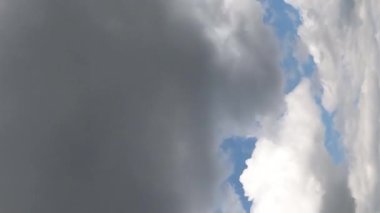 Evrensel Cloudscape arka planı. Beyaz bulutlu mavi gökyüzü. Kabarık beyaz bulutlar. Yaz mavisi gökyüzü zaman aşımı. Yumuşak beyaz bulutlar oluşur. Dikey video.