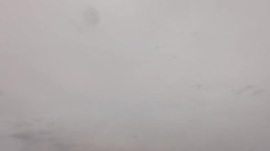 Gri bulutlu gökyüzü. Zaman ayarlı. Sakin, huzurlu bir hava. Hızla ilerleyen bulutlar, kabarık kümülüs bulutları. Doğal bulut manzarası, meteoroloji geçmişi. Gökyüzünde yüzen dramatik kümülüs bulutları.