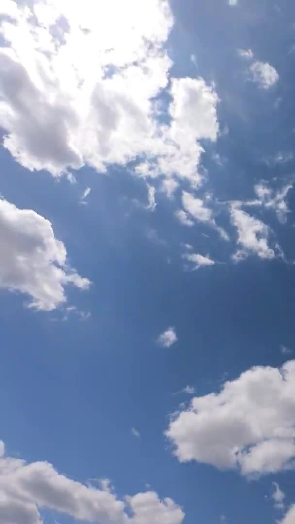 春の晴れた青空を背景に 白色のサークル雲やふわふわの円丘の雲の上に輝く明るい太陽光線の日の光のフレア Bロールのタイムラプス — ストック動画