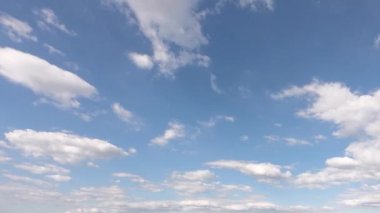 Beyaz kümülüs bulutları açık mavi gökyüzüne karşı. Zaman Ayarı videosu.