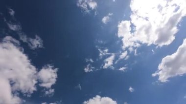 Güzel, güneşli, mavi gökyüzünün alçak açılı zaman çizelgesi. Beyaz kabarık bulutlar. B-filmi. Mavi Gökteki Güneş Parlaması. 