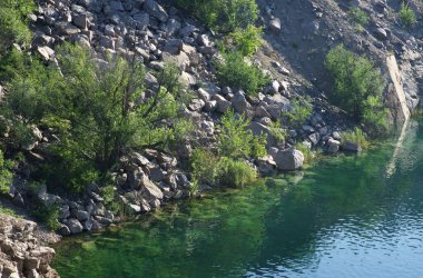 Ukrayna 'nın Mygia köyü yakınlarındaki Kara Göl kıyısında. Sel basmış bir granit ocağının yanındaki göl..