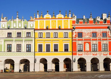 Zamosc, Polonya, 27 Aralık 2020. Polonya 'nın Zamosc kentindeki tarihi Büyük Pazar Meydanı' ndaki renkli binaların manzarası. Fotoğraf güneşli bir kış gününde çekildi..