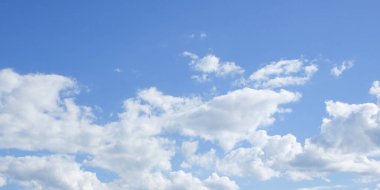Güneşli havada açık mavi gökyüzüne karşı kümülüs beyaz bulutlar. Arkaplan.