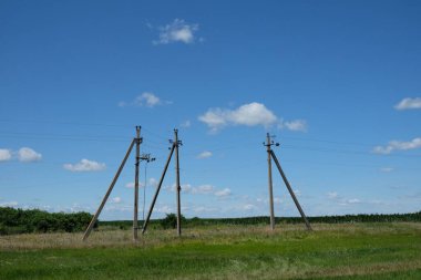 Alanda üç büyük elektrik direği var..