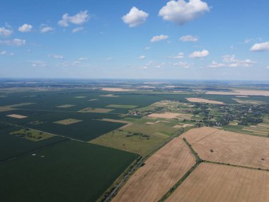 Güzel tarımsal manzara, açık arazi mavi gökyüzü ve beyaz bulutlar. Kuş bakışı tarlalar.