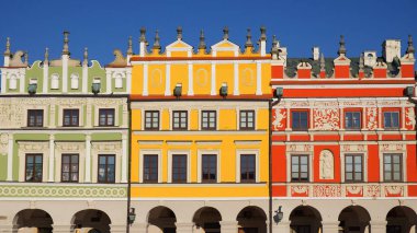 Polonya 'nın Zamosc kentindeki tarihi Büyük Pazar Meydanı' ndaki renkli binaların manzarası. Fotoğraf güneşli bir kış gününde çekildi..