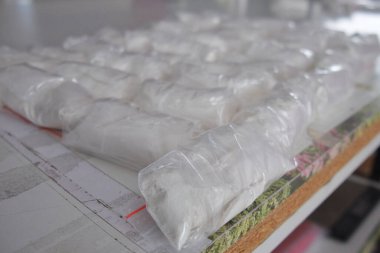 Beyaz tozla dolu saydam keseler. Küçük keselerde beyaz toz paketlenmiş..