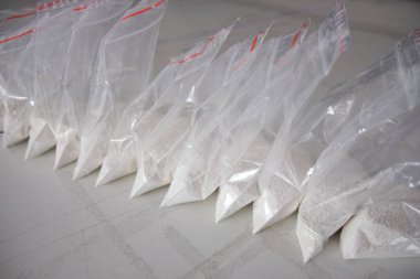 Beyaz tozla dolu saydam keseler. Küçük keselerde beyaz toz paketlenmiş..