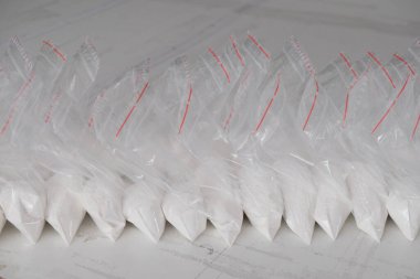 Beyaz tozla dolu saydam keseler. Küçük keselerde beyaz toz paketlenmiş..