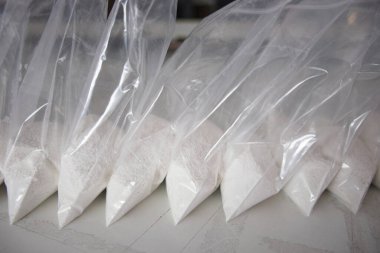 Beyaz tozla dolu saydam keseler. Küçük keselerde beyaz toz paketlenmiş..