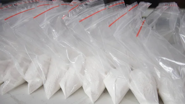 Beyaz tozla dolu saydam keseler. Küçük keselerde beyaz toz paketlenmiş..