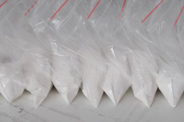 Beyaz tozla dolu saydam keseler. Küçük keselerde beyaz toz paketlenmiş..