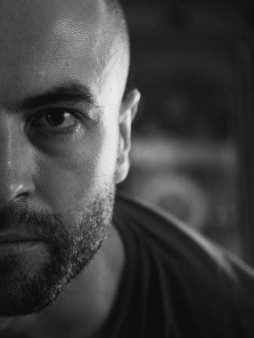 Beyaz bir adamın bakışları. Portre, yakın plan. Yüzünde sakalı olan bir adam. Siyah ve beyaz resim.