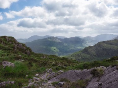Idyllic İrlanda manzara fotoğrafı. Bulutlu gökyüzünün altındaki yeşil tepeler. Seyahat rehberi ve turizm fotoğrafçılığı için ideal.