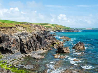Kayalık oluşumlu kıyı manzarası. Dokulu kayalar ve berrak suyla deniz manzarası.